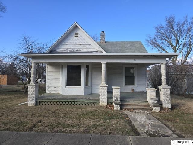 view of front of home with a front yard and covered porch