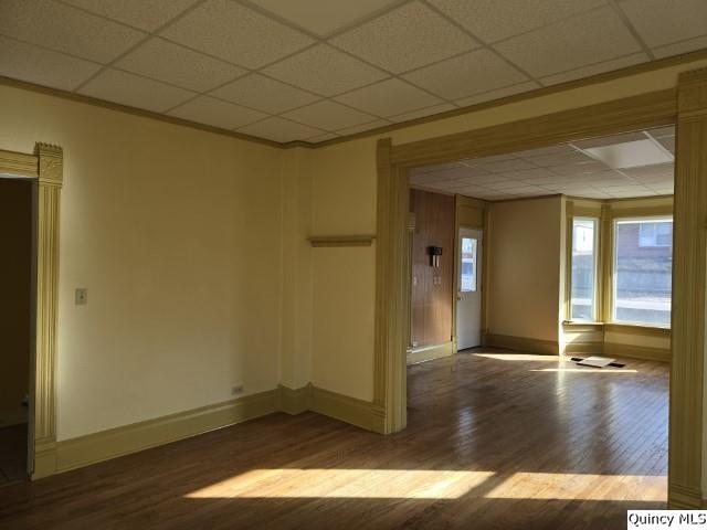 unfurnished room featuring a drop ceiling and hardwood / wood-style floors