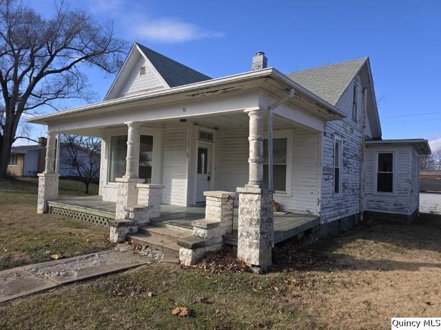 view of front of house with covered porch and a front yard