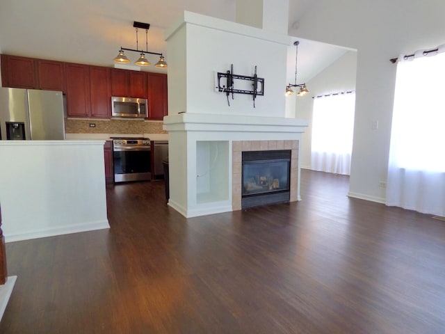 unfurnished living room with a fireplace, dark wood-type flooring, and vaulted ceiling