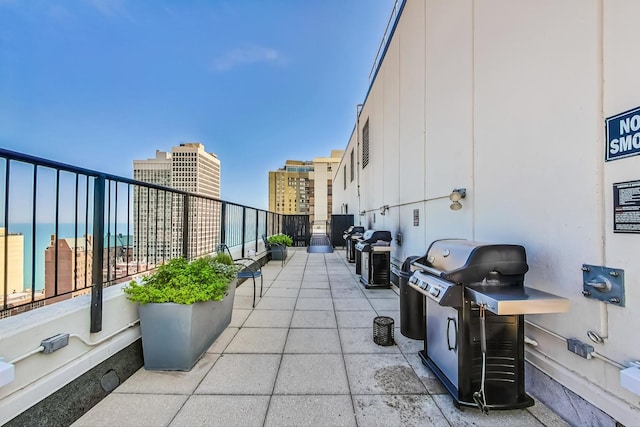 view of patio with a water view and a grill