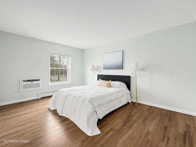 bedroom with wood-type flooring, a wall mounted AC, and baseboard heating