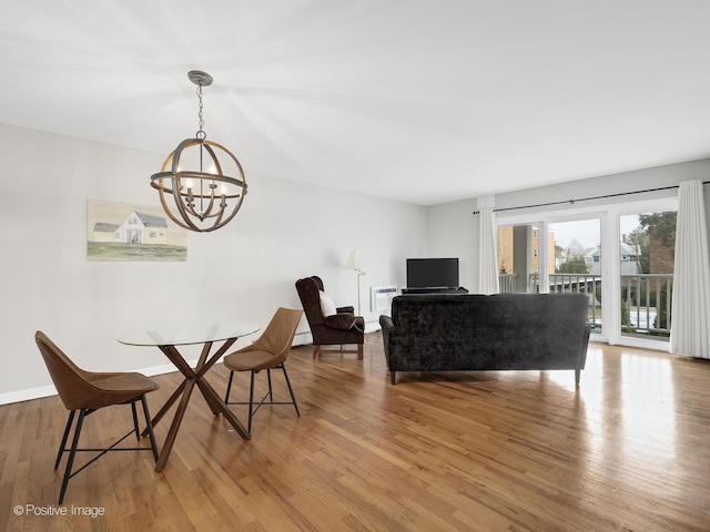 dining space featuring hardwood / wood-style floors and an inviting chandelier