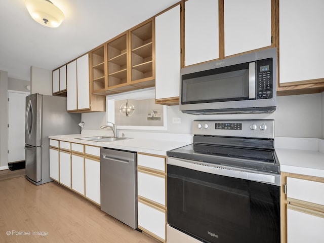 kitchen featuring white cabinetry, appliances with stainless steel finishes, sink, and light hardwood / wood-style flooring