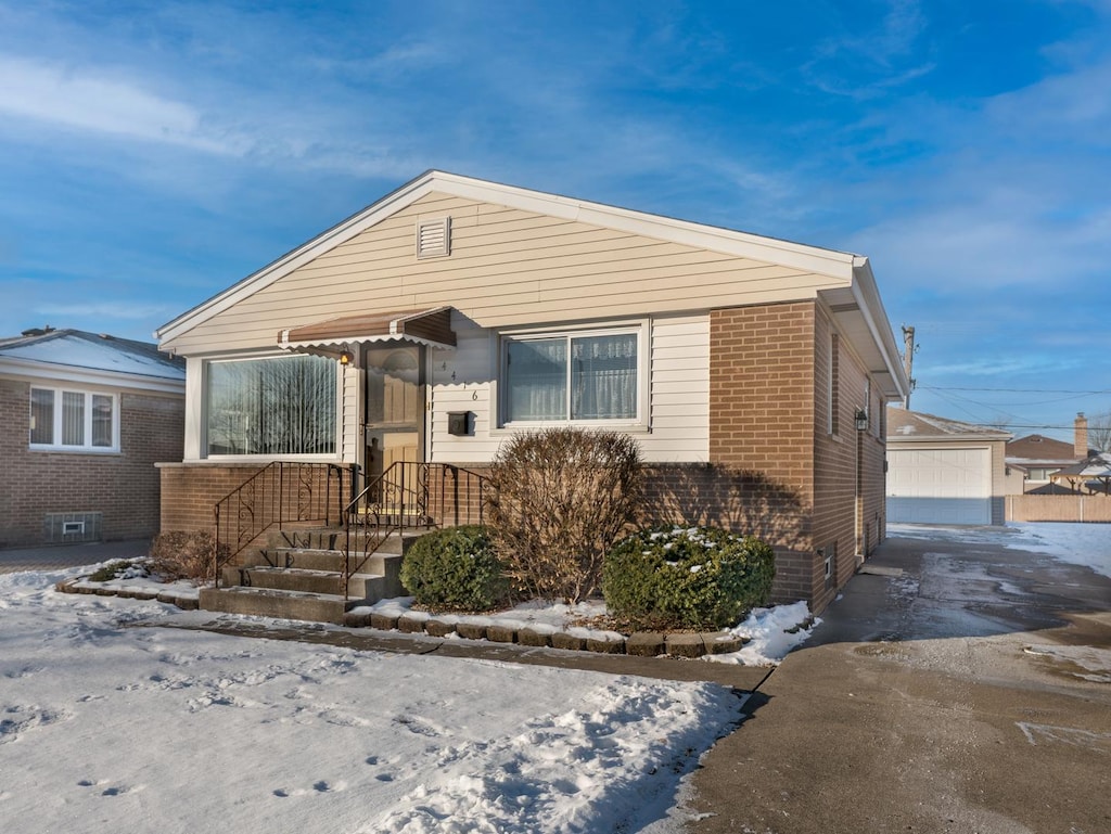 view of front of home with a garage and an outdoor structure