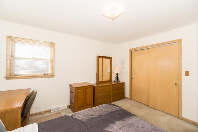 bedroom with a closet and light colored carpet