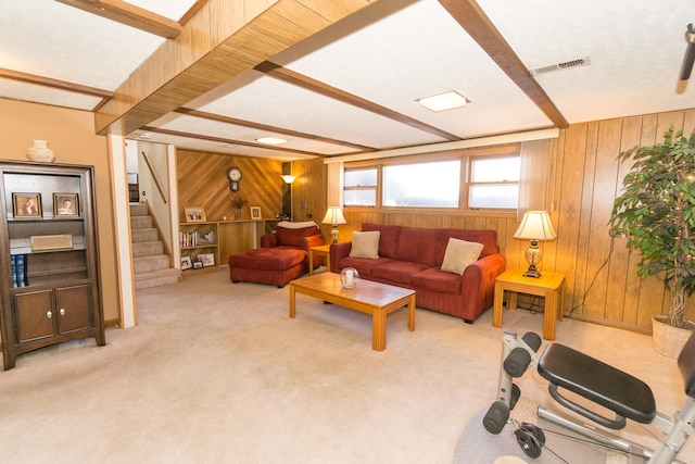 carpeted living room with wooden walls and beam ceiling