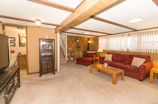 carpeted living room featuring wood walls and beam ceiling