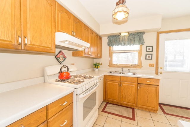 kitchen featuring sink, light tile patterned floors, dishwasher, and white gas range oven