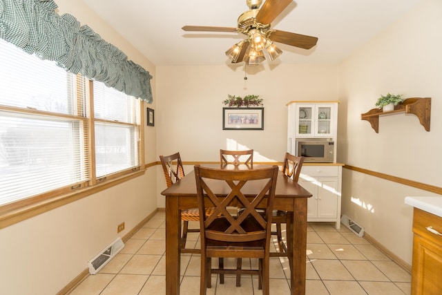 dining space with ceiling fan and light tile patterned flooring