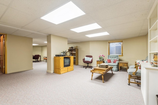 living room featuring carpet floors and a drop ceiling