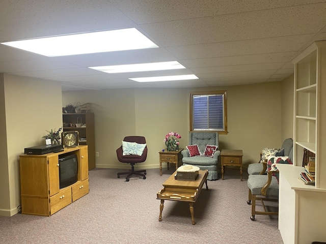 living area featuring light colored carpet and a paneled ceiling