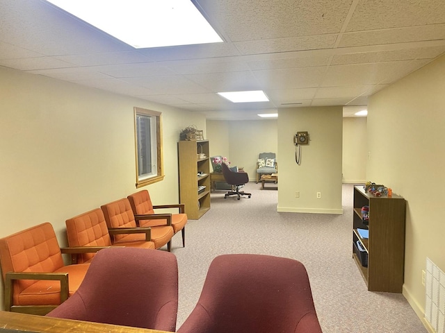 carpeted living room with a drop ceiling