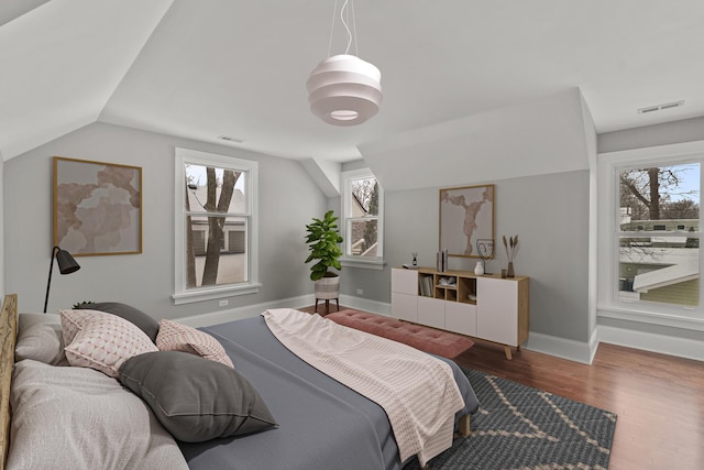 bedroom with lofted ceiling, hardwood / wood-style flooring, and multiple windows