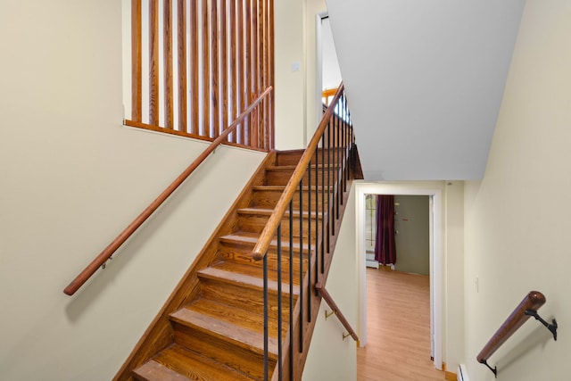 stairs featuring a baseboard radiator and wood-type flooring