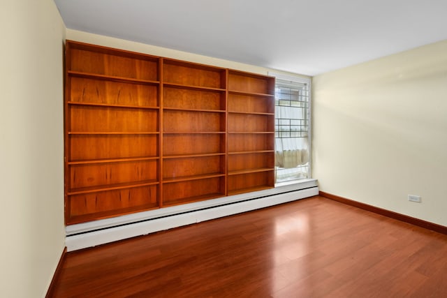 unfurnished room featuring a baseboard radiator and wood-type flooring