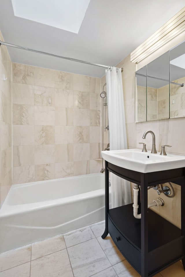 bathroom featuring sink, a skylight, and shower / bathtub combination with curtain