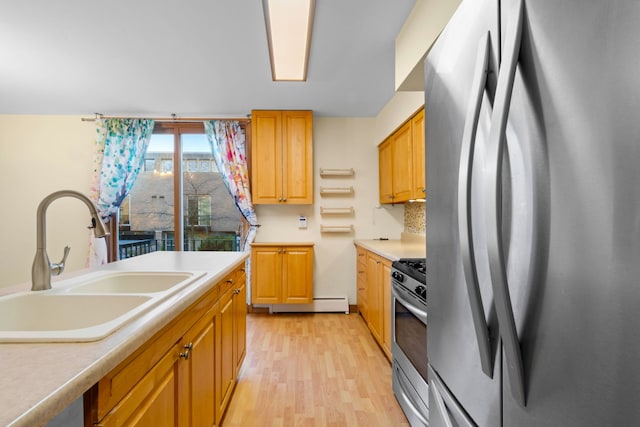 kitchen with light hardwood / wood-style flooring, appliances with stainless steel finishes, backsplash, and sink