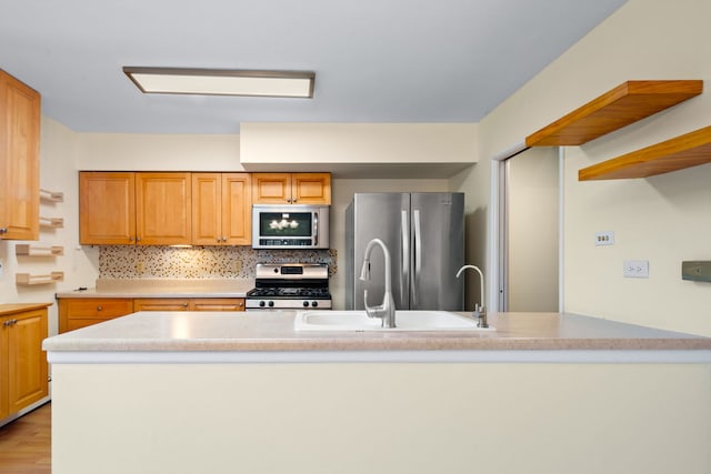 kitchen with light wood-type flooring, appliances with stainless steel finishes, decorative backsplash, and sink