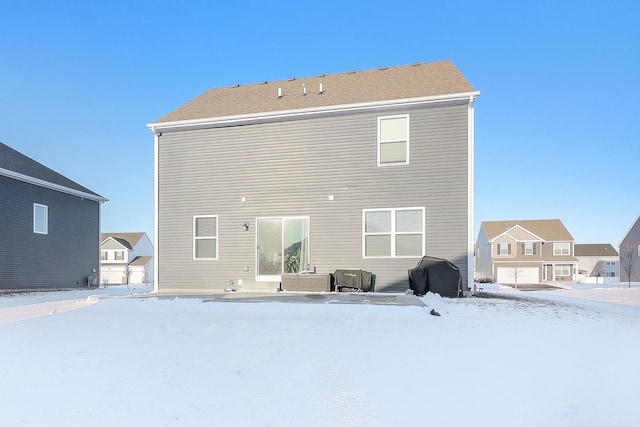 view of snow covered back of property