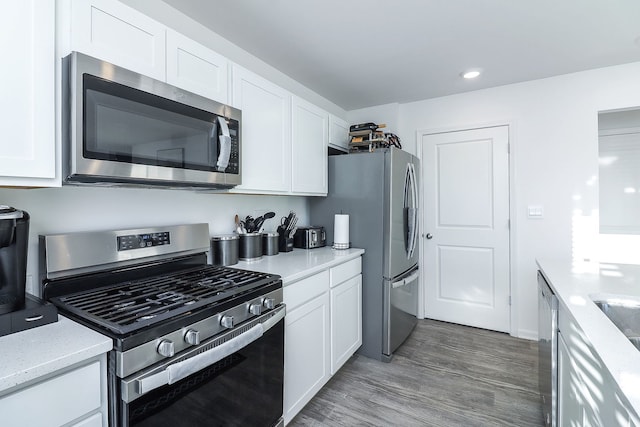 kitchen featuring stainless steel appliances, dark hardwood / wood-style floors, and white cabinets