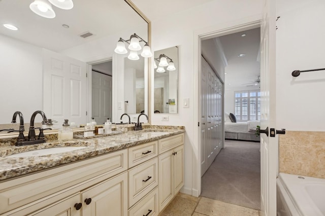 bathroom with ceiling fan, vanity, and a washtub