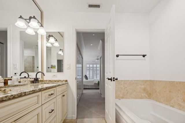 bathroom with ceiling fan, a tub to relax in, and vanity