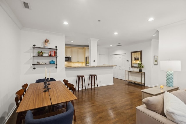 dining area with dark hardwood / wood-style flooring and ornamental molding