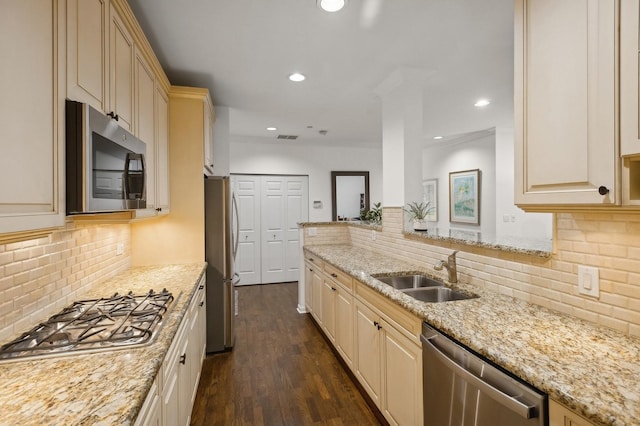 kitchen featuring light stone countertops, appliances with stainless steel finishes, sink, and dark wood-type flooring