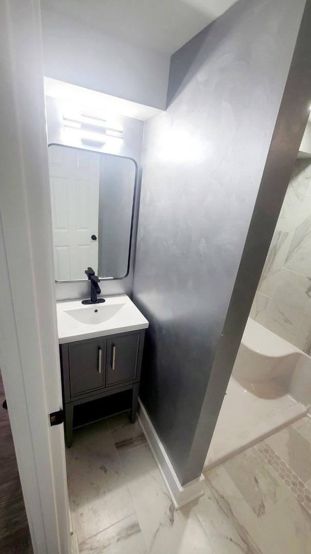 bathroom featuring a shower and vanity