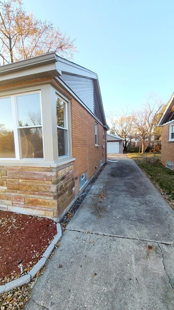 view of side of home with a garage and an outbuilding