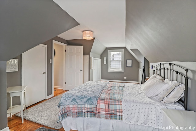 bedroom featuring light hardwood / wood-style flooring and vaulted ceiling