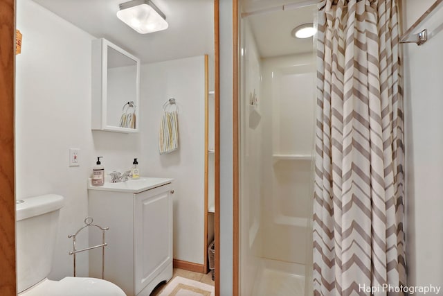 bathroom featuring curtained shower, toilet, and vanity