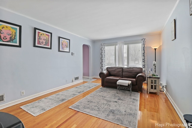 living room with crown molding and light hardwood / wood-style flooring