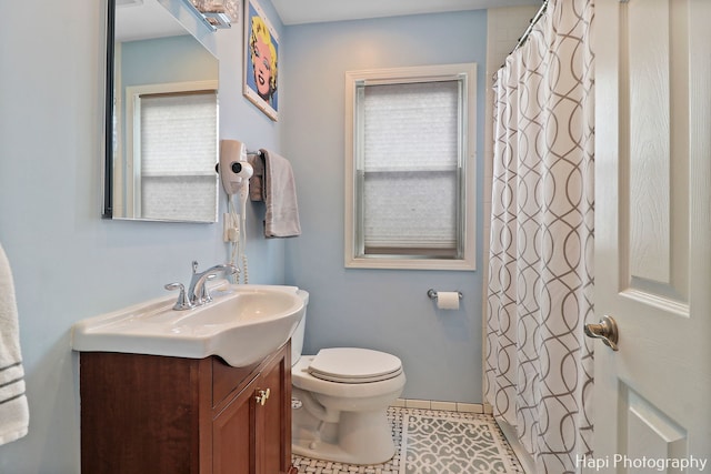 bathroom with toilet, tile patterned flooring, and vanity