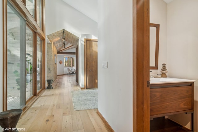 hall with light hardwood / wood-style flooring and a high ceiling