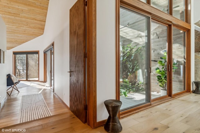 corridor with lofted ceiling, wood ceiling, and light wood-type flooring