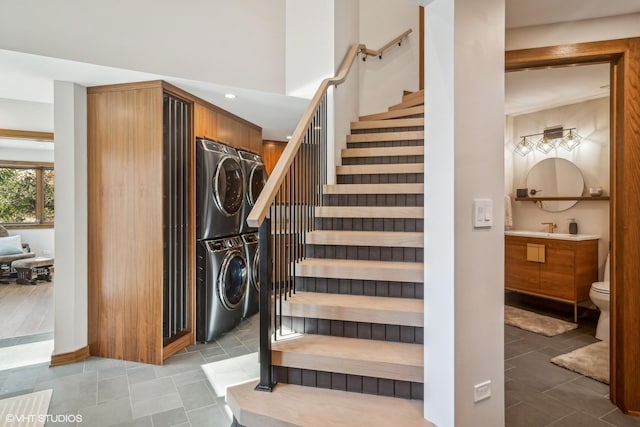 stairs with sink and stacked washer / dryer