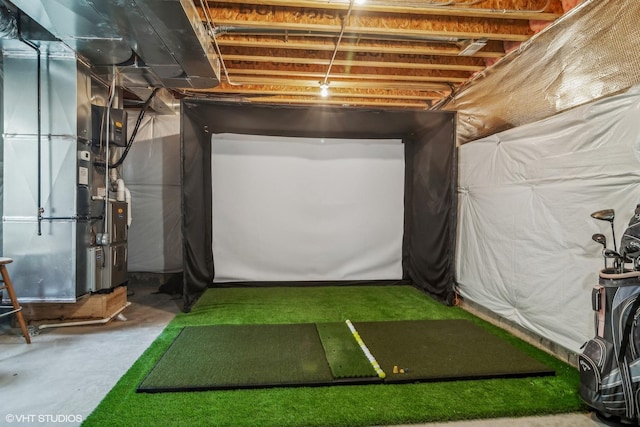 basement with golf simulator and heating unit