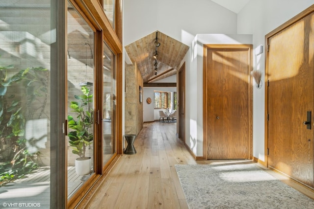 corridor featuring lofted ceiling and light hardwood / wood-style flooring