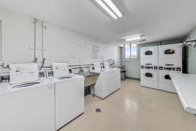 laundry room featuring stacked washing maching and dryer, washing machine and clothes dryer, and sink