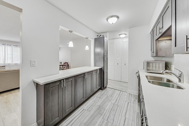 kitchen with decorative light fixtures, decorative backsplash, and sink