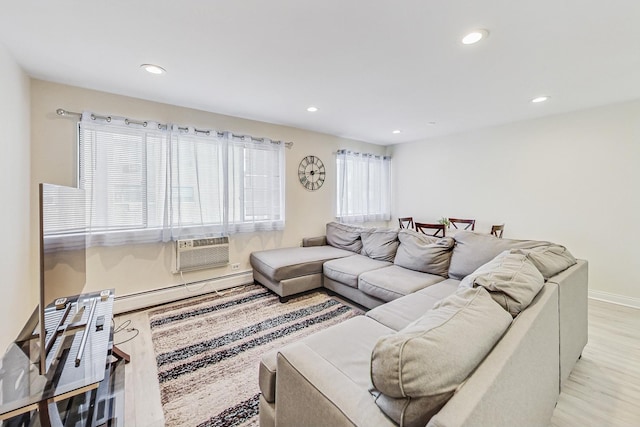 living room featuring a healthy amount of sunlight, a baseboard radiator, and light hardwood / wood-style floors