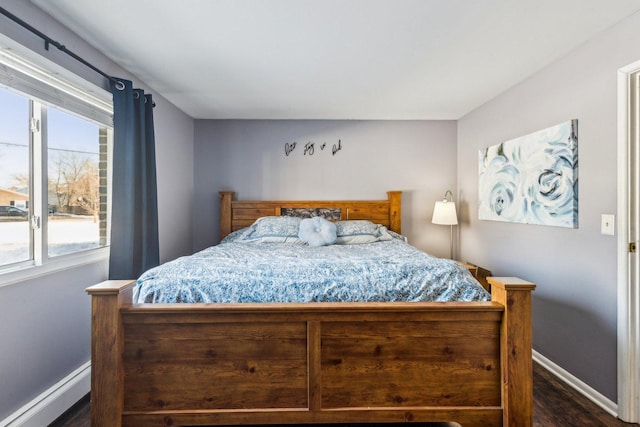 bedroom with a baseboard radiator and dark hardwood / wood-style flooring