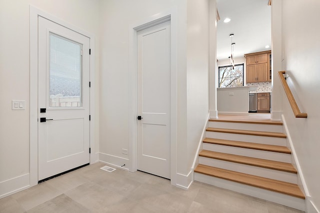 interior space featuring baseboards, stairway, and recessed lighting