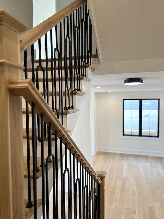 stairway featuring baseboards and wood finished floors