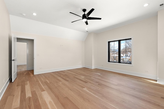 spare room featuring baseboards, lofted ceiling, ceiling fan, light wood-type flooring, and recessed lighting