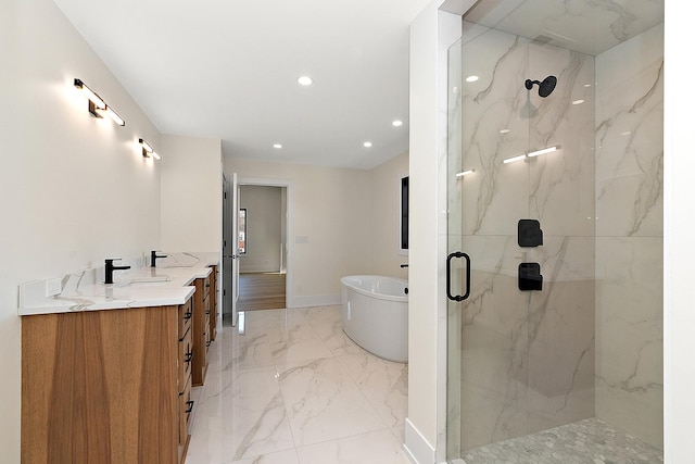 full bathroom with a marble finish shower, marble finish floor, vanity, a freestanding tub, and recessed lighting