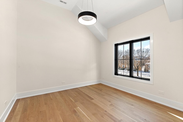 unfurnished room featuring vaulted ceiling, light wood-style flooring, and baseboards