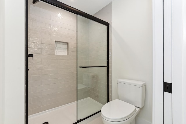 bathroom featuring a shower stall and toilet